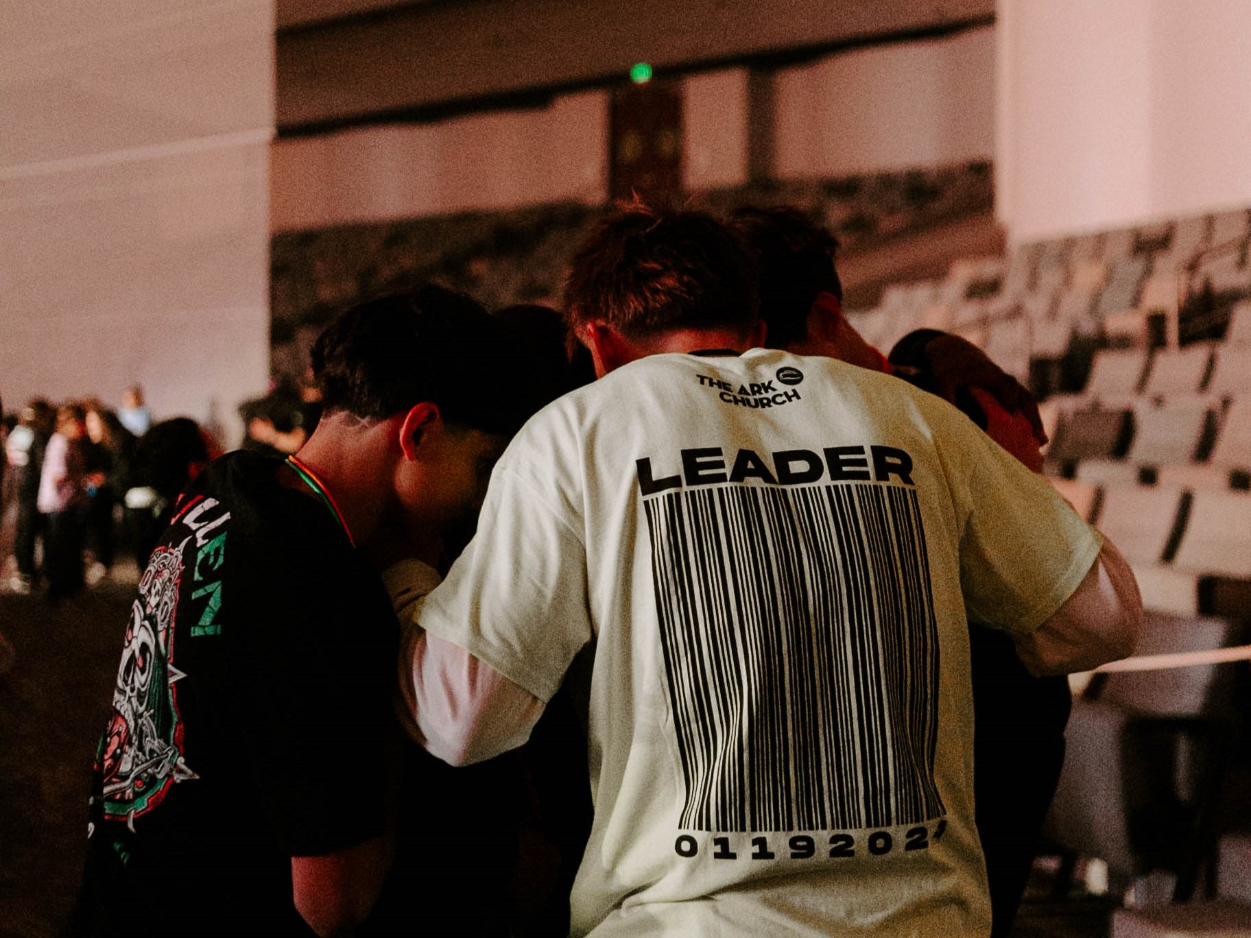 church youth group students praying in a huddle