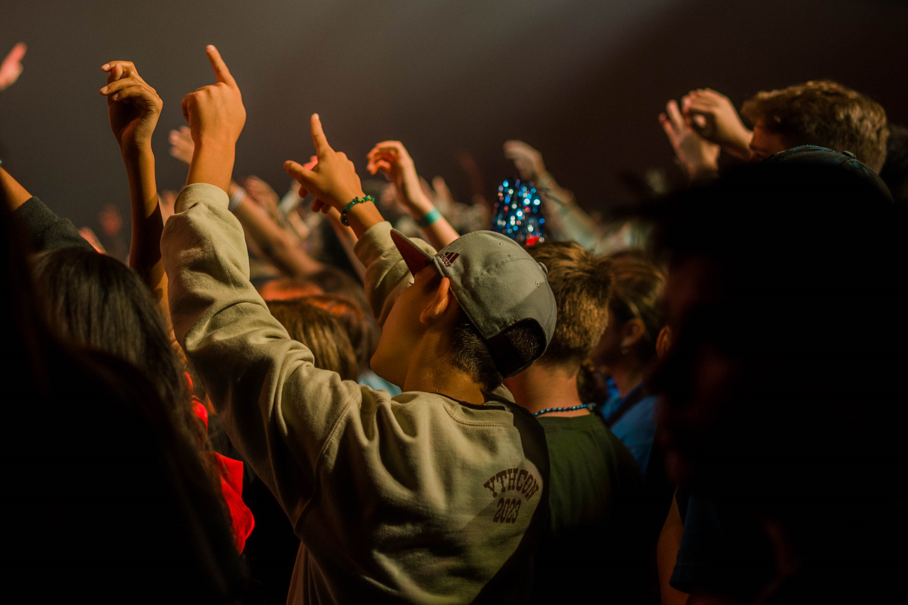 youth group raising hands singing during church worship service